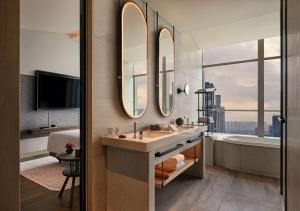 a bathroom with a sink and a tub and mirror at Andaz Nanjing Hexi in Nanjing