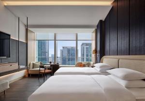 a hotel room with two beds and a television at Andaz Nanjing Hexi in Nanjing