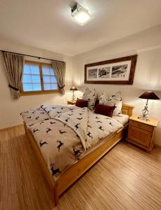 een slaapkamer met een groot bed met vogels erop bij Laax Cozy Apartment Ski Bus in front of the Door in Laax
