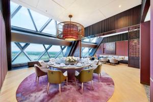 una sala da pranzo con tavolo e sedie di Hilton Huzhou Nanxun a Huzhou