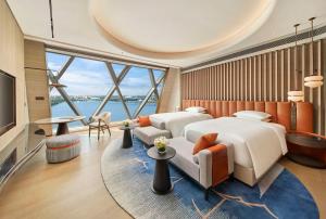 una camera d'albergo con due letti e una grande finestra di Hilton Huzhou Nanxun a Huzhou