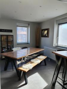 une salle à manger avec une grande table et des bancs en bois dans l'établissement Appartement, proche Europa-Park Colmar Strasbourg, à Sundhouse