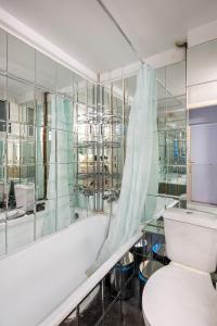 y baño con aseo y bañera con paredes de cristal. en Spacious Central Apt Downtown en Atenas