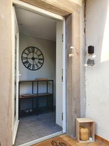 une porte menant à une pièce avec une horloge sur le mur dans l'établissement Appartement, proche Europa-Park Colmar Strasbourg, à Sundhouse