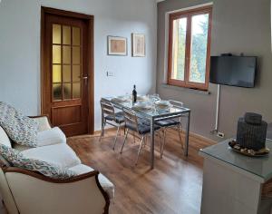 un soggiorno con tavolo, sedie e TV di Casa Martini a Pecetto