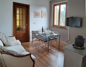 a living room with a table and chairs and a television at Casa Martini in Pecetto
