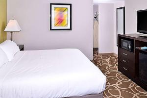 Säng eller sängar i ett rum på Elimwood Hotel, A Ramada by Wyndham