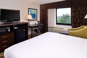 سرير أو أسرّة في غرفة في Elimwood Hotel, A Ramada by Wyndham