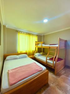 薩利納斯的住宿－HOTEL MARLUZ，一间卧室配有两张床和一张双层床。