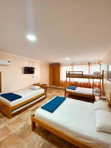 薩利納斯的住宿－HOTEL MARLUZ，带三张床和电视的客房