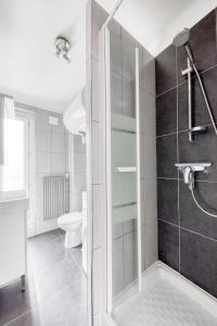 La salle de bains est pourvue d'une douche et de toilettes. dans l'établissement Studio lumineux Maisons-Laffitte, à Maisons-Laffitte