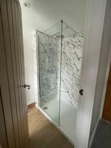 um chuveiro com uma porta de vidro na casa de banho em No. 3 A cosy spot for 4 em Cawood
