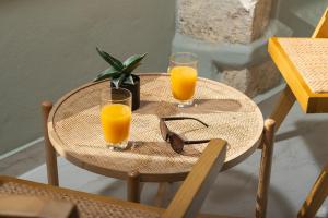 a small table with two glasses of orange juice at The Alma City Suites in Chania