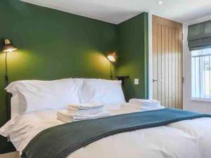 a bedroom with green walls and a bed with white pillows at No. 3 A cosy spot for 4 in Cawood