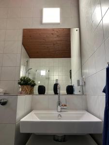 Baño blanco con lavabo y espejo en Maksimirhouse, en Zagreb