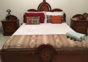 a bedroom with a large wooden bed with pillows at Twins in Solarino +11 photos