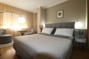 a bedroom with a large white bed and a chair at Hotel Rio Umbertide in Umbertide