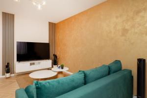 a living room with a blue couch and a tv at Ursus Nova Apartment with Parking by Renters Prestige in Warszawa