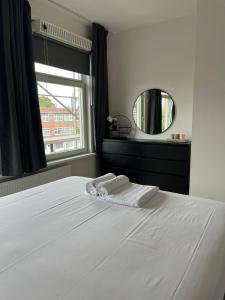 a bedroom with a white bed with a mirror at Cosy Apartment in the Hague! in The Hague