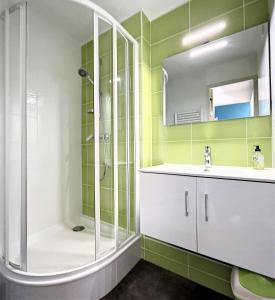 ein Bad mit einer Dusche und einem Waschbecken in der Unterkunft travelski home classic - Résidence Soyouz in Le Corbier