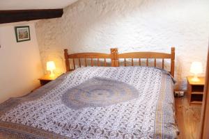 a bedroom with a bed with a blue and white comforter at Panorama Gîtes Certes in Gaudiès +15 photos