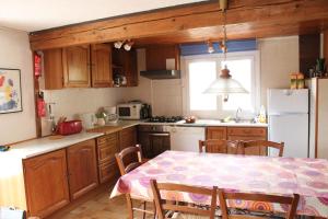 a kitchen with a table and a kitchen with a refrigerator at Panorama Gîtes Certes in Gaudiès
