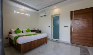 1 dormitorio con 1 cama y puerta de madera en Hotel Grand Vista en Noida