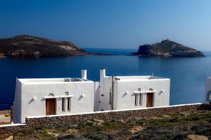 biały budynek na brzegu wody w obiekcie Panormos Art Villas & Suites w mieście Panormos