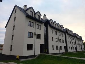 a large white building with a black roof at Apartament Glamour Okrzei in Sandomierz
