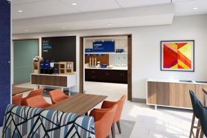 a restaurant with a table and chairs and a counter at Holiday Inn Express & Suites Bessemer - Birmingham SW, an IHG Hotel in Bessemer