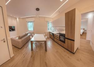 a kitchen and living room with a table and a couch at Attici Alba e Tramonto in Brescia