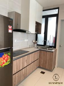 a kitchen with a sink and a refrigerator at Kuching Near Batu Kawa Cozy Apartment P Residence in Kuching