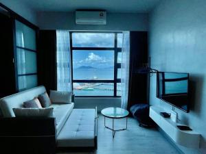 a living room with a white couch and a large window at Nerv Homestay JQ T1 intermediate- seaview in Kota Kinabalu