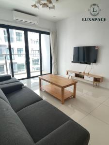 a living room with a couch and a flat screen tv at Kuching Near Batu Kawa Cozy Apartment P Residence in Kuching