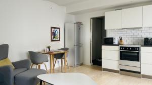 uma cozinha com um frigorífico e uma mesa com cadeiras em ApartmentInCopenhagen Apartment 1207 em Copenhague