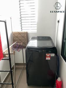 a small black refrigerator in a room with a window at Kuching Near Batu Kawa Cozy Apartment P Residence in Kuching