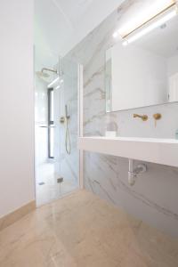 ein weißes Badezimmer mit Waschbecken und Dusche in der Unterkunft Apartamentos Casa-Palacio Santa Pola in Ronda + 81 Fotos