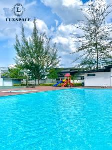 a swimming pool with a playground and blue water at Kuching Near Batu Kawa Cozy Apartment P Residence in Kuching