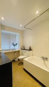 a bathroom with a tub and a toilet and a sink at ApartmentInCopenhagen Apartment 1207 in Copenhagen