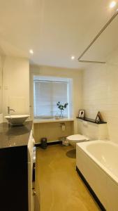 uma casa de banho com uma banheira, um WC e um lavatório. em ApartmentInCopenhagen Apartment 1207 em Copenhague