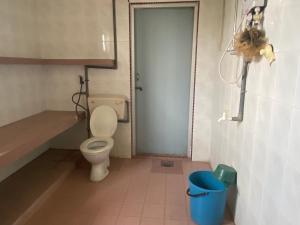 a bathroom with a toilet and a blue trash can at OYO 90885 Bera Pentagon Inn in Kampong Kerayong