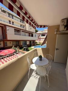 Un balcón con una mesa y sillas en un edificio. en Estudio ROMÁNTICO La Carihuela, en Torremolinos