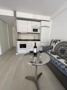Sala de estar con mesa y 2 copas de vino en Estudio ROMÁNTICO La Carihuela, en Torremolinos