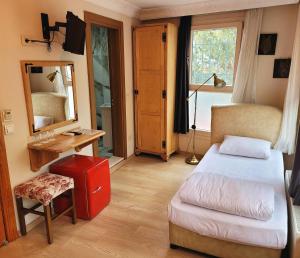 um quarto com uma cama, um espelho e uma mala vermelha em Masif House em Istambul
