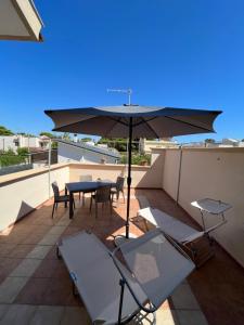 un patio avec une table et un parasol sur le toit dans l'établissement Sea la vie casa vacanza, à Tarente