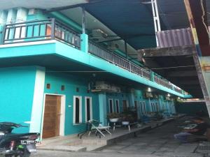 a blue building with a balcony on top of it at OYO 93306 Rinjani Guest House in Balikpapan