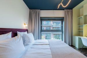 a bedroom with a large bed with a window at The Garden Suites by Suite030 in Berlin