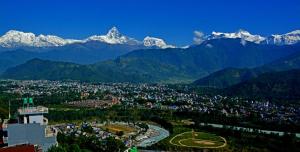 a city with snow capped mountains in the background at Hotel Himalayan Home Lamagaun Pokhara 10 minute drive from tourist place lakeside rent Rooms in Pokhara