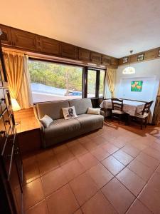 uma sala de estar com um sofá e uma grande janela em Chalet dei Conti em Pescocostanzo