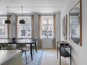 a dining room with a table and some windows at Sanders Main - Popular Two-Bedroom Duplex Apartment Next to Magical Nyhavn in Copenhagen